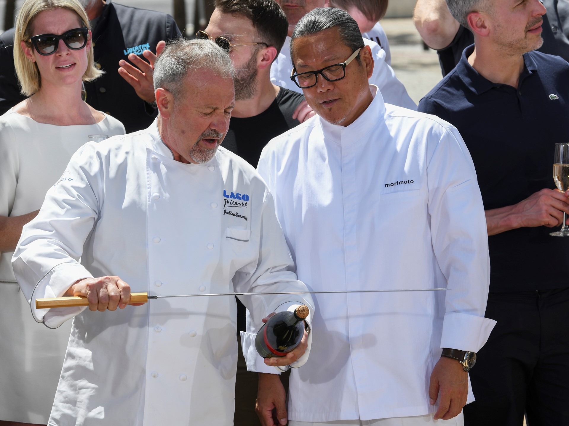 Chef Julian Serrano demonstrates how to remove the cork to Chef Masaharu Morimoto