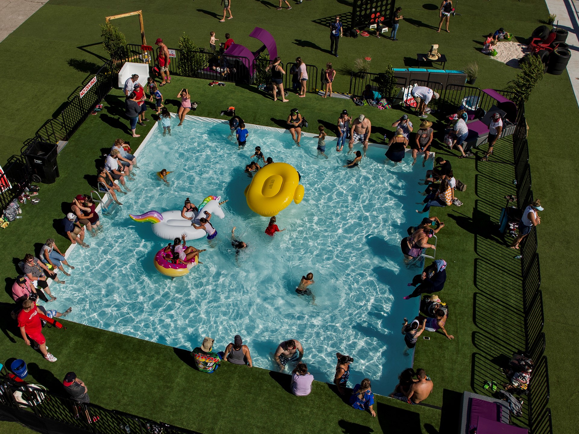 Racing fans cool off in the pool within the "Turn 4 Turn Up" fan area