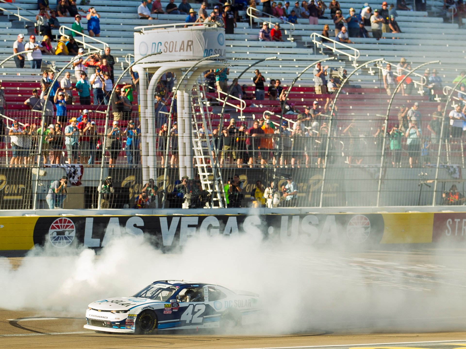 Ross Chastain #42 does a burnout at the finish line after winning the NASCAR Xfinity Series DC Solar 300