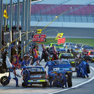 Pit crews swarm their trucks during the NASCAR Camping World Truck Series