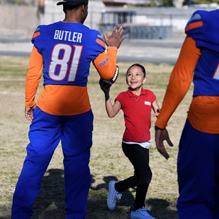 Genisses Jimenez hands a football back to Boise State's Akilian Butler