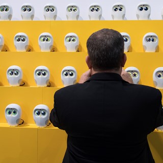 An attendee takes a photo of robots from Ling Technologies during the second day of CES
