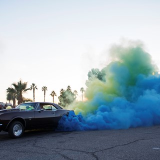 Tom Thiessen sends up clouds of yellow and blue smoke from the tires of his 1969 Camaro