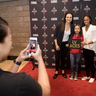 Lauren Mercado has her photo taken with Las Vegas Aces Kayla McBride, left, and Moriah Jefferson