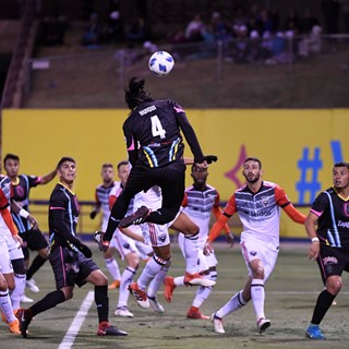 Players watch as Las Vegas Lights Joel Huiqui heads the ball towards the goal