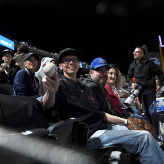 A fan holds up a foul ball