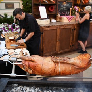A pig roasts on a spit at the Buddy V's booth