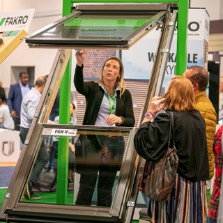 In the Fakro booth a representative demonstrates a the way a skylight window opens