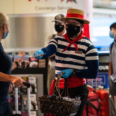 Venetian Las Vegas Gondolier hands an arriving visitor a mask at McCarran International Airport June 26, 2020