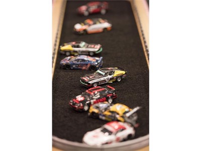 Slot cars are parked in the "infield" of a race track at the Specialty Equipment Market Association (SEMA) Show
