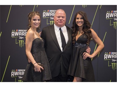 Chip Ganassi poses for a photo with his daughter Tessa Ganassi, left, and a Monster Energy model