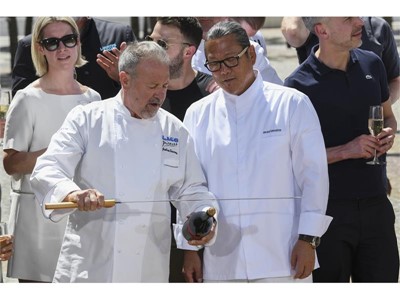 Chef Julian Serrano demonstrates how to remove the cork to Chef Masaharu Morimoto