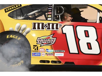 A passenger laughs while riding in Kyle Busch's car during the 2018 NASCAR Burnout Blvd