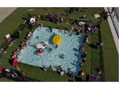 Racing fans cool off in the pool within the "Turn 4 Turn Up" fan area