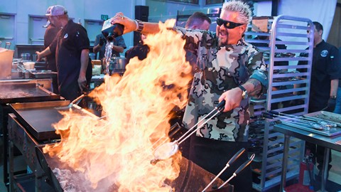 Guy Fieri pours tequila on a charcoal fire
