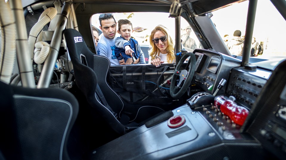 A family checks out the interior of one of the racers in Las Vegas as the Mint 400 4 Wheel Parts Vehicle Procession