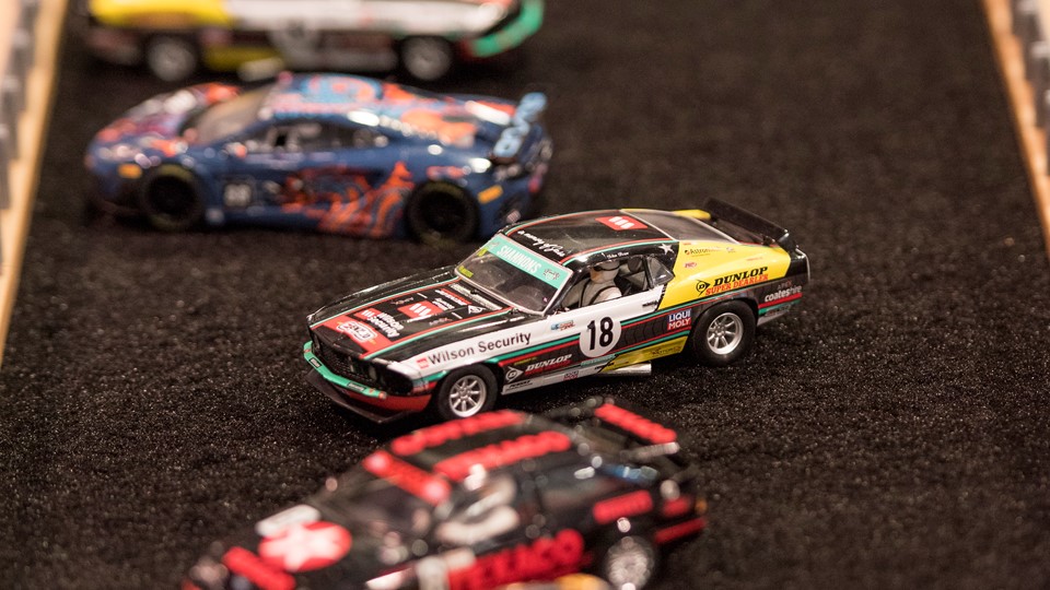Slot cars are parked in the "infield" of a race track at the Specialty Equipment Market Association (SEMA) Show