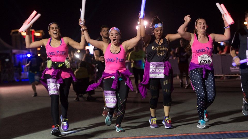 A group of women cross the finish line during the Rock 'n' Roll Las Vegas Marathon 5K run