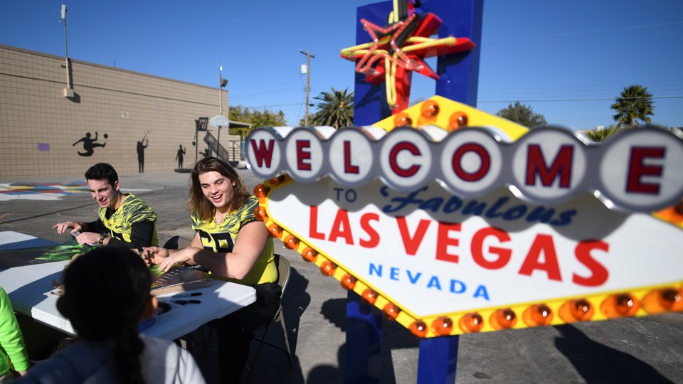 Oregon Ducks quarterback Taylor Alie and Oregon Ducks offensive lineman Shane Lemieux hand out autographed posters
