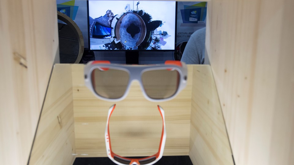 Glasses which film in 360 degrees, with footage displayed in the background, are seen during the first day of CES