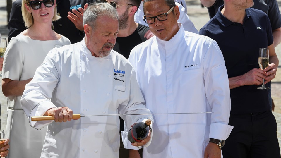 Chef Julian Serrano demonstrates how to remove the cork to Chef Masaharu Morimoto