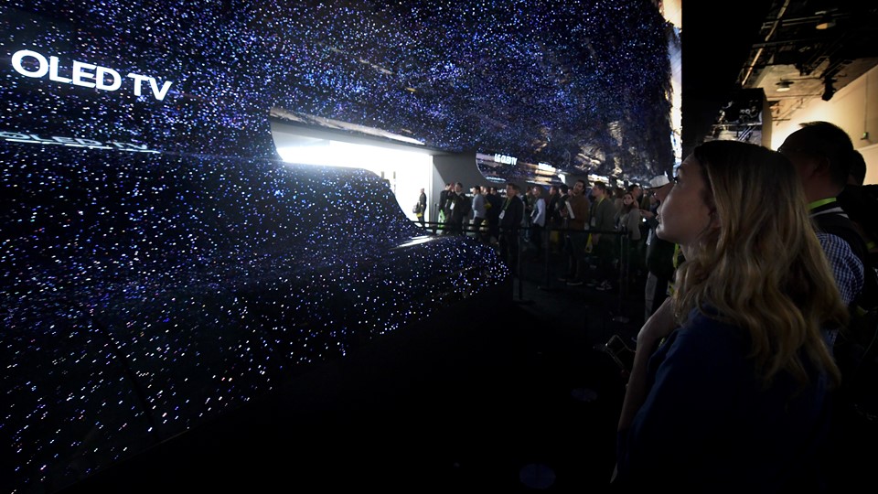 Attendees walk through the entry to the LG booth