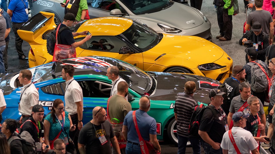 Visitors crowd cars on display