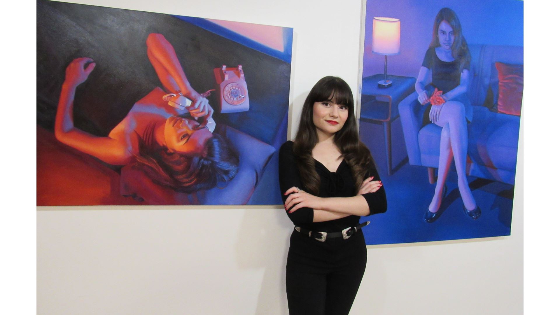 A girl standing between two paintings