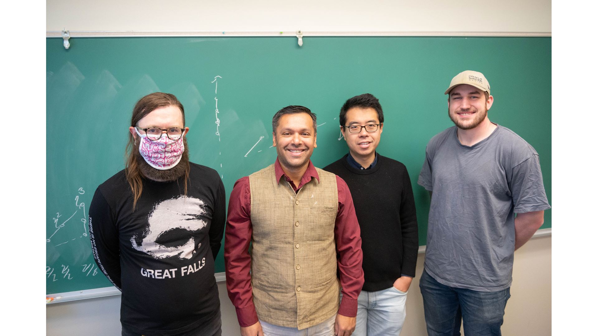Four men in front of a chalkboard