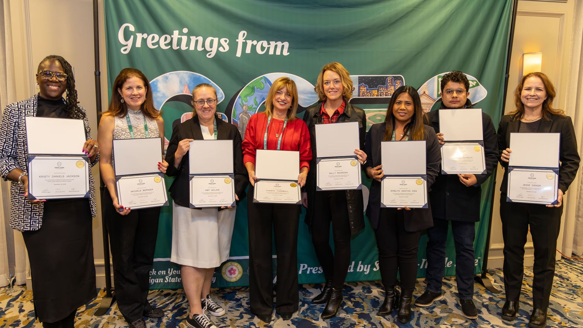 IMAGE DESCRIPTION A group of seven women and one man standing holding certificates