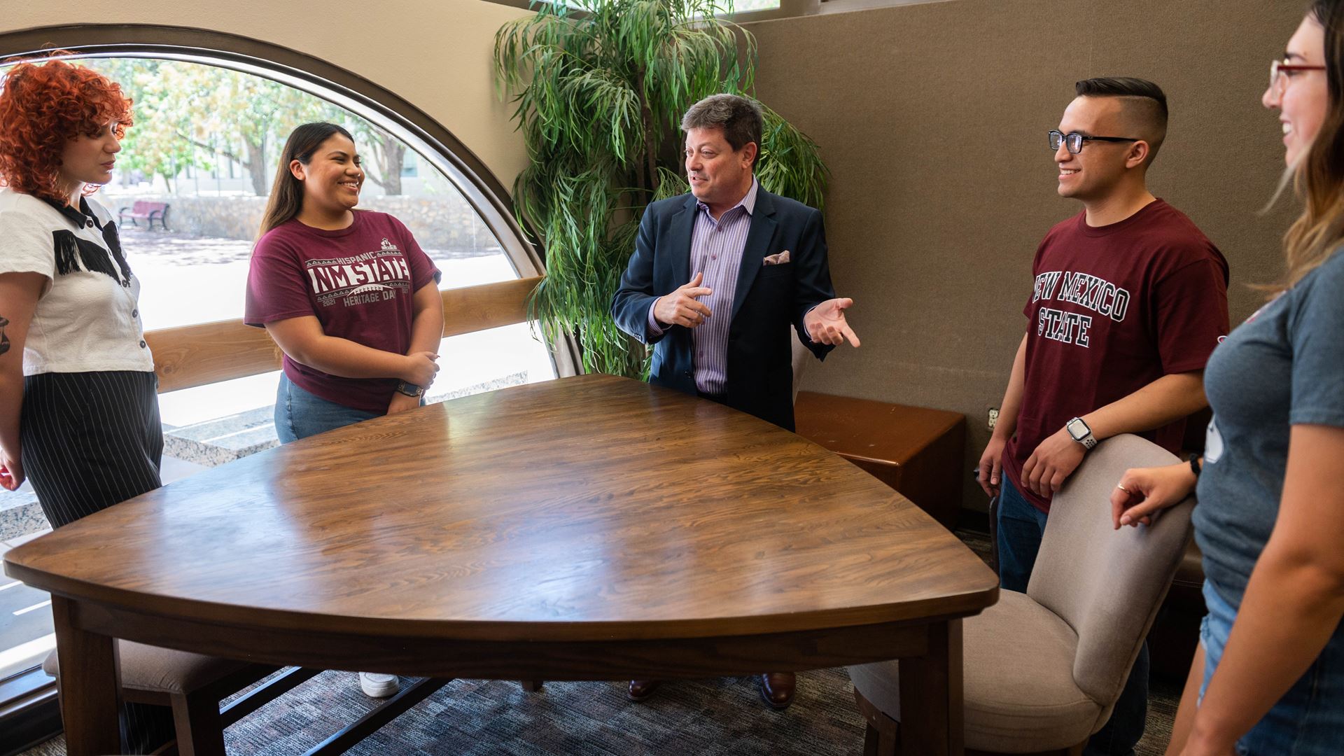 Photo of Dean Bryan Ashenbaum with students at College of Business Complex