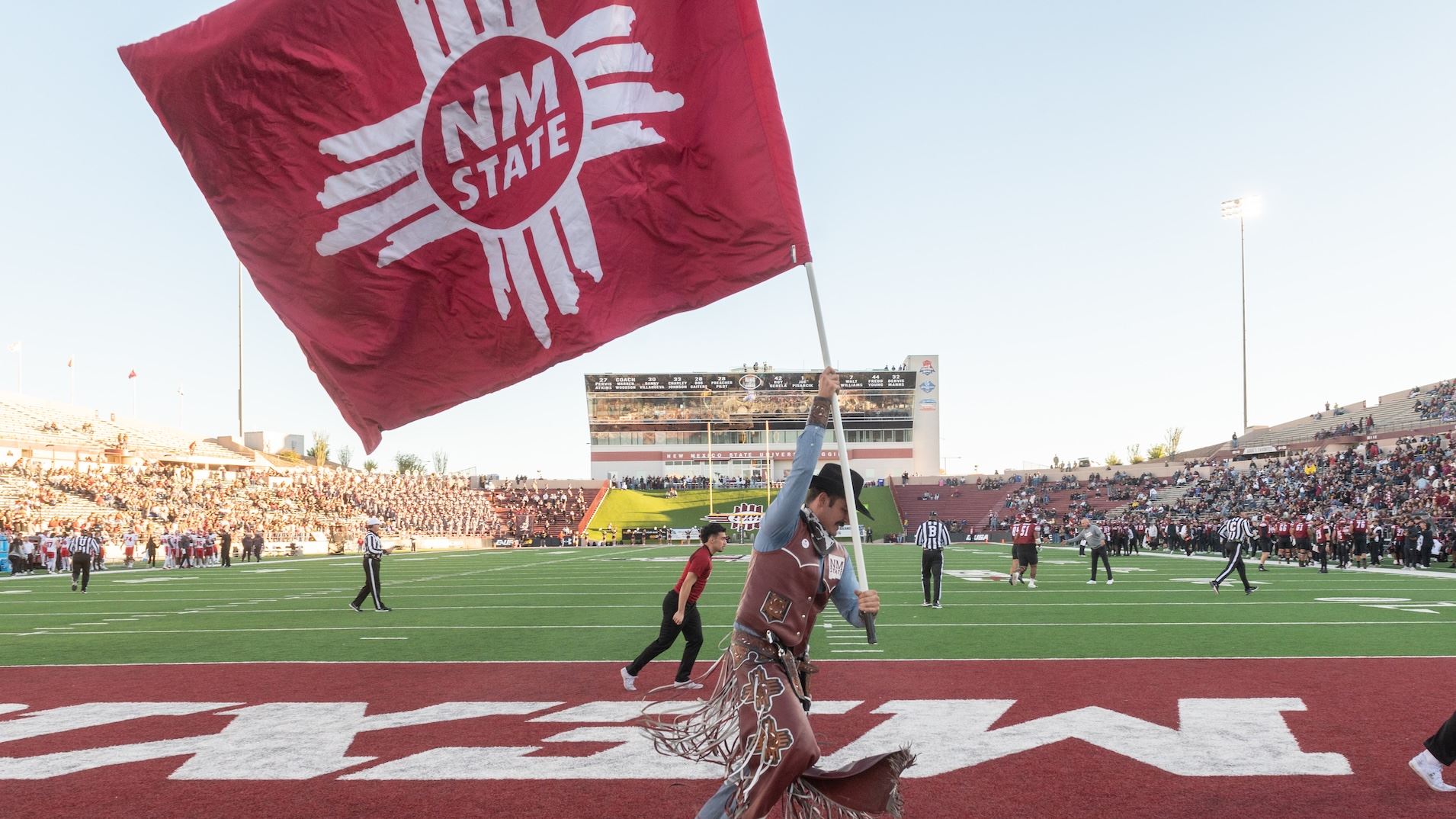 IMAGE DESCRIPTION A man dressed as Pistol Pete waves a flag on a football field
