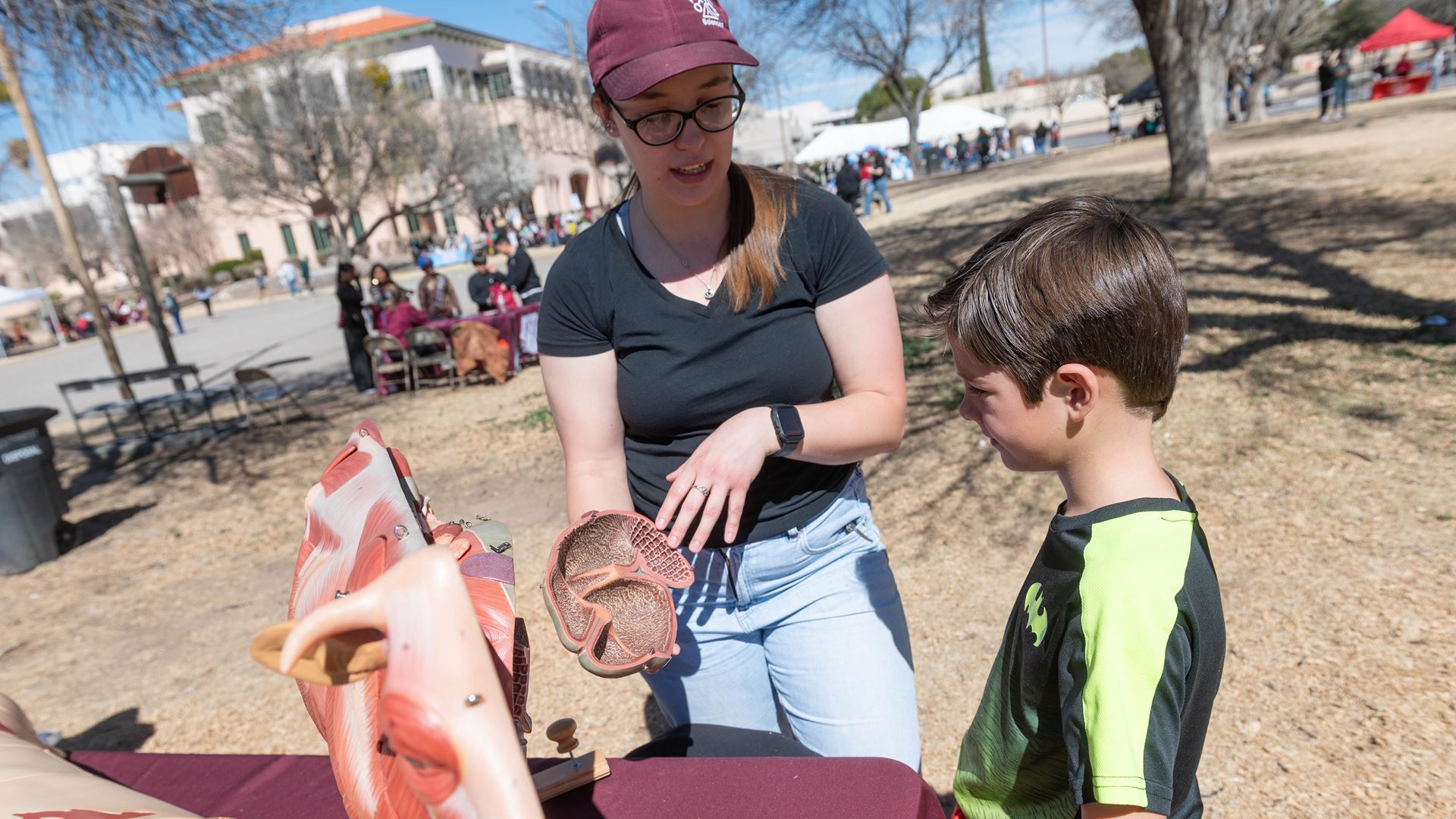 IMAGE DESCRIPTION A woman showing a heart from an anatomical model to a young boy