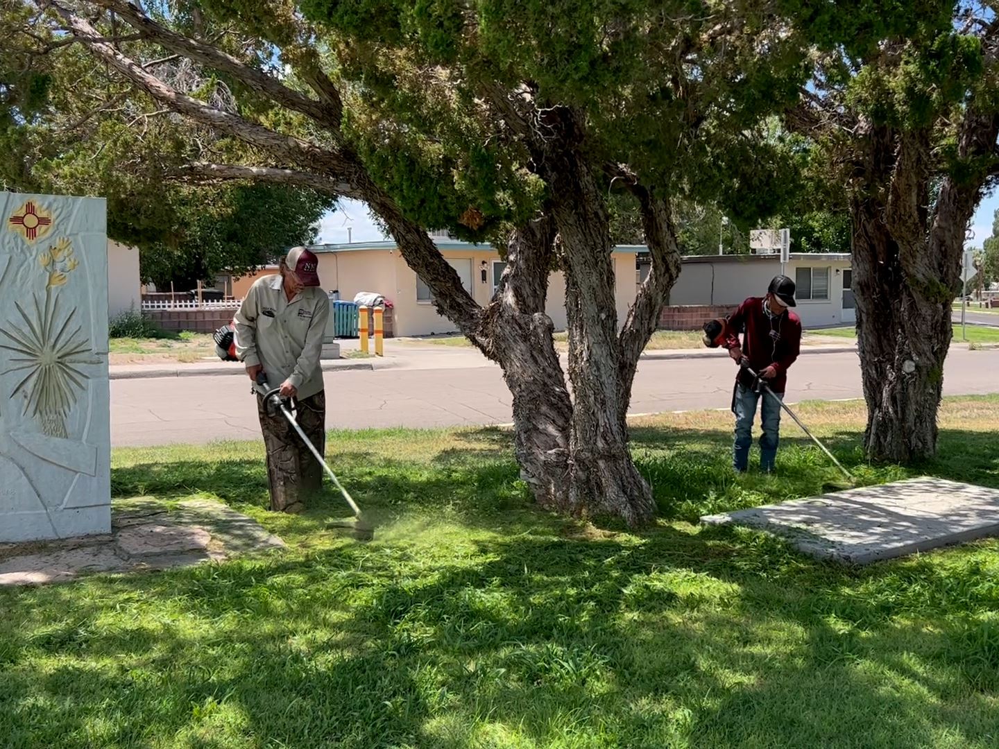 Grounds crew members maintaining weed control at Tom Fort Village