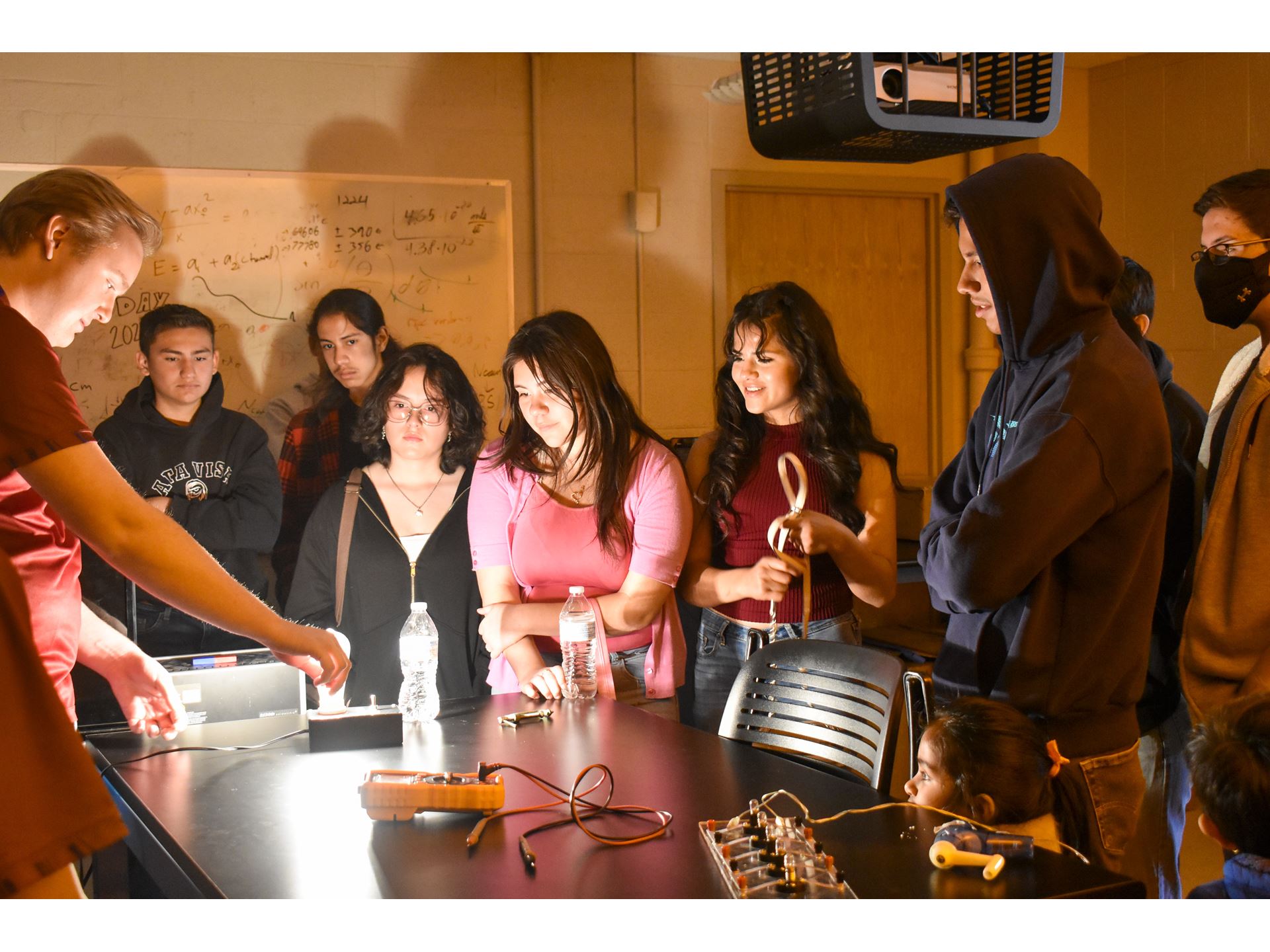 People standing around a light bulb