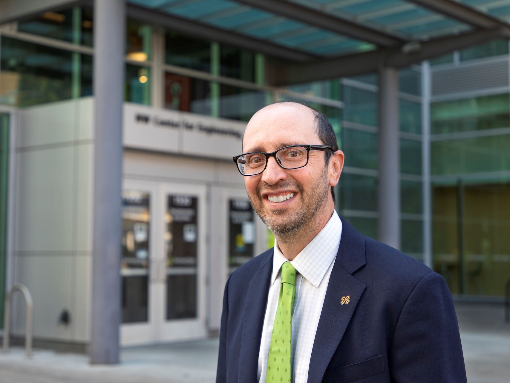 IMAGE DESCRIPTION A man in a suit standing outside of a building