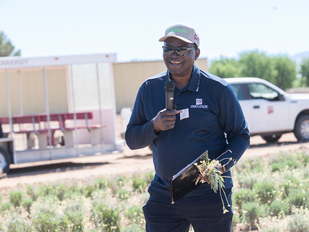 IMAGE DESCRIPTION A man standing in a field holding a microphone