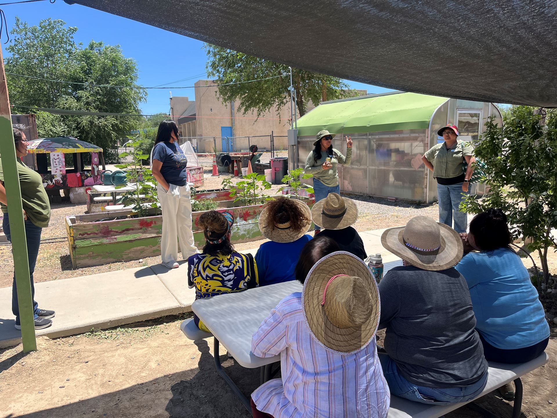 IMAGE DESCRIPTION A woman speaking to a group of people outdoors