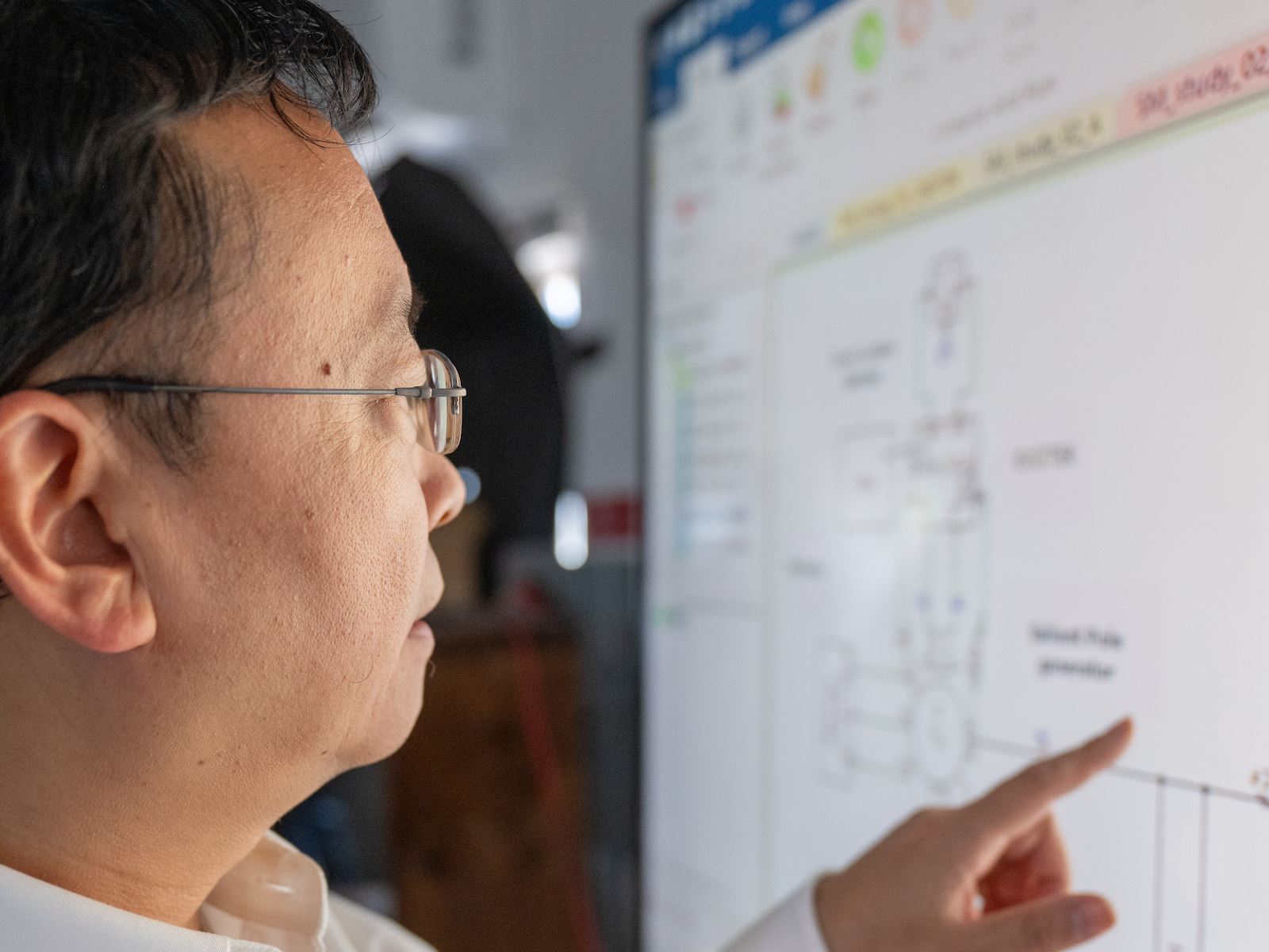 IMAGE DESCRIPTION Man standing next to a screen with diagrams