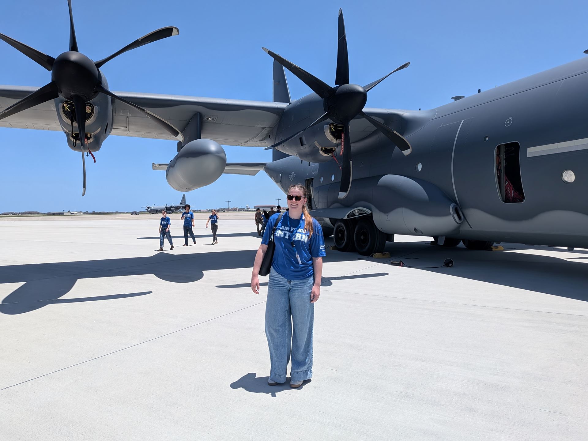 Description A woman stands in front of a plane