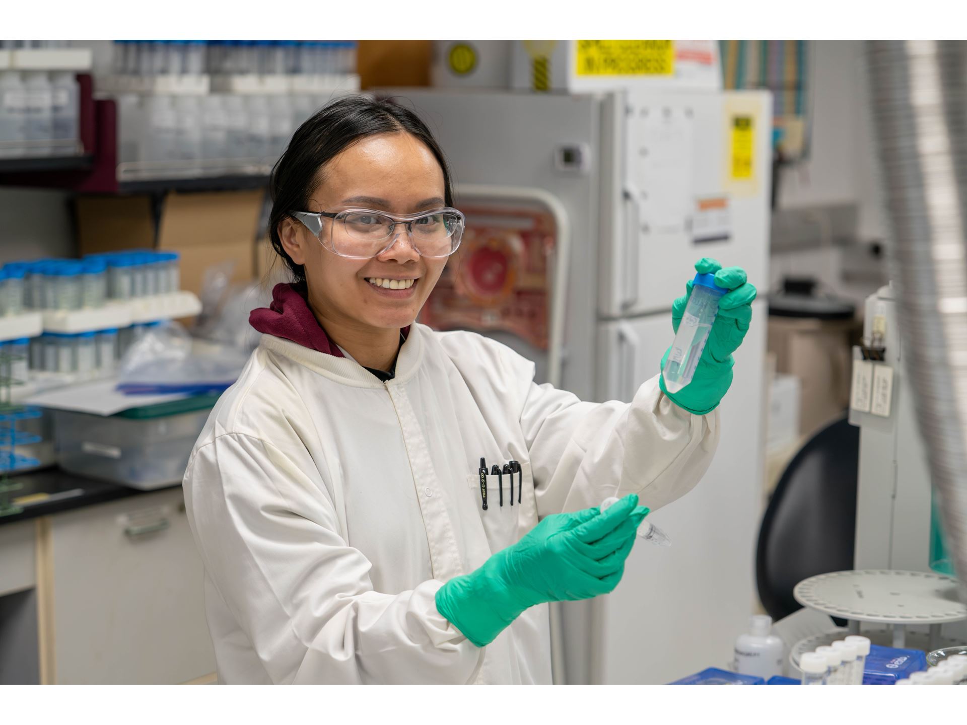 Description A researcher holds up two tubes with a liquid sample