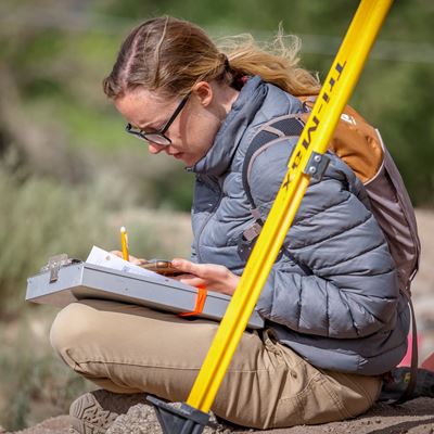 Undergraduate student Sage Drake taking notes at the Plaza de Carnué site. (Photo by Tom Conelly)