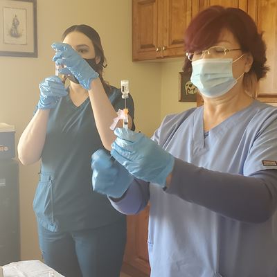 Krystal Pouliot (left) and Gloria Martinez, registered nurses with the New Mexico Department of Health, prepare COVID-19