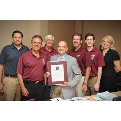 Kevin Boberg, center, received the Above and Beyond Award in 2014 from then-Chancellor Garrey Carruthers and the NMSU Bo