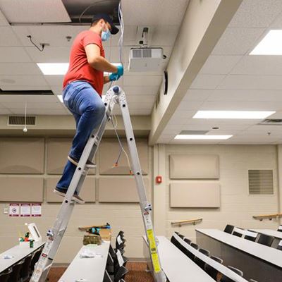 Luis Tovar, of New Mexico State University’s Information and Communications Technologies, sets up a hybrid classroom on