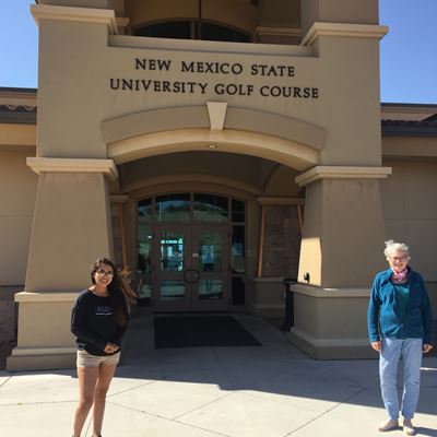Nancy McMillian, department head of geological sciences, stands with a volunteer in front of the NMSU golf course to pic