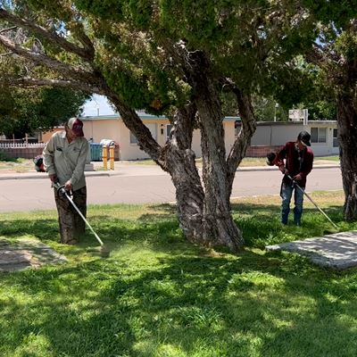 Grounds crew members maintaining weed control at Tom Fort Village