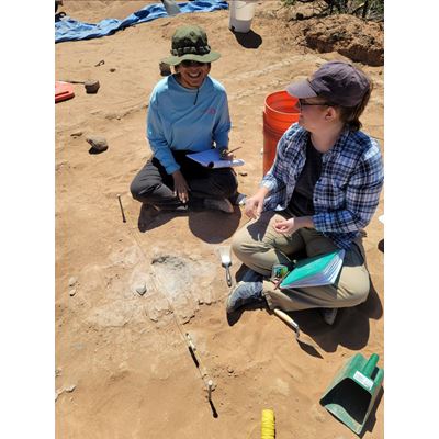 Two students sitting with field tools