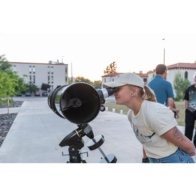 Girl looking through a telescope at the event in 2022