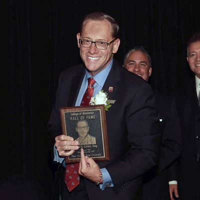 Photo of Brian Col n receiving College of Business Hall of Fame plaque